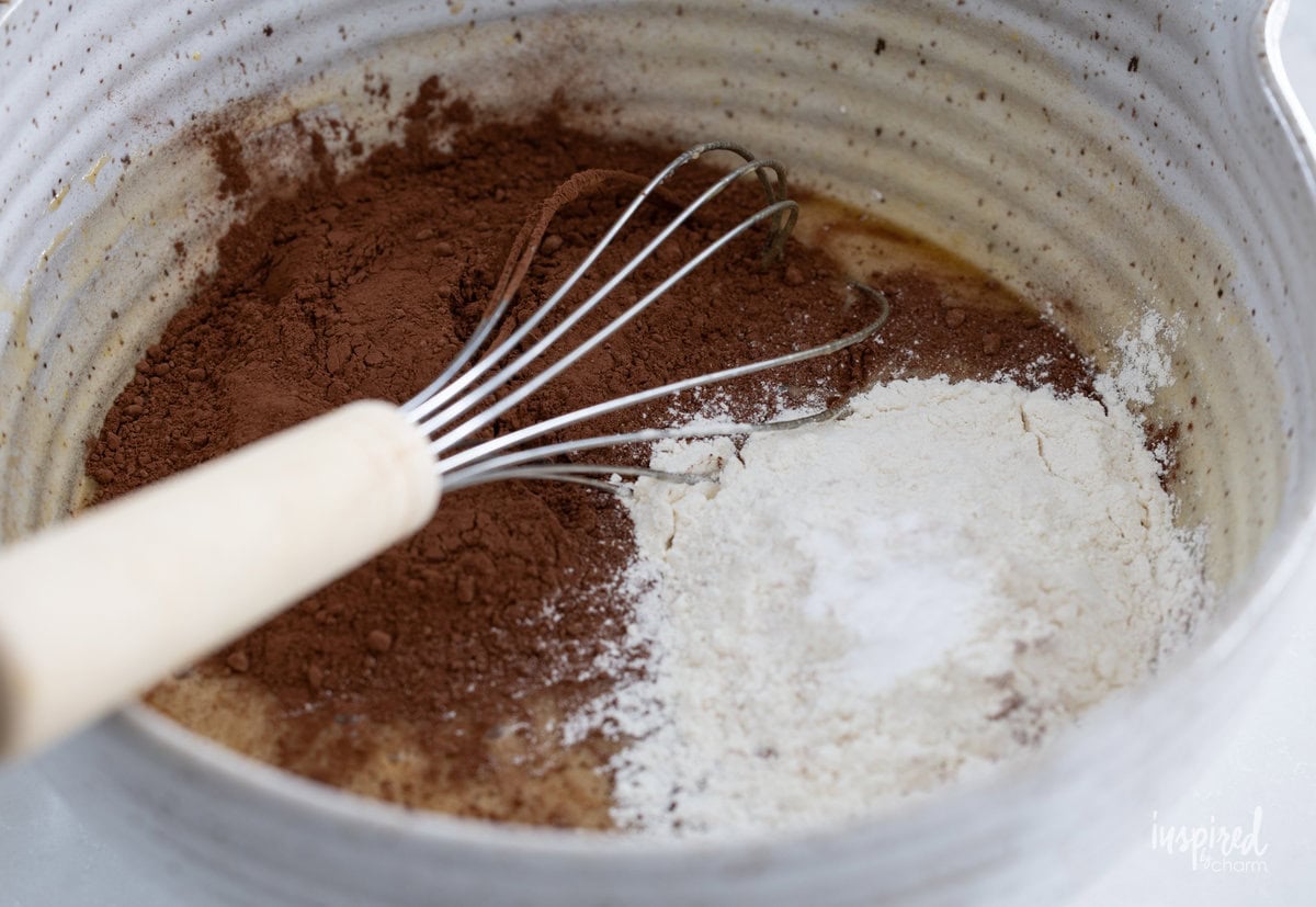 brownie batter ingredients in a bowl with a whisk.