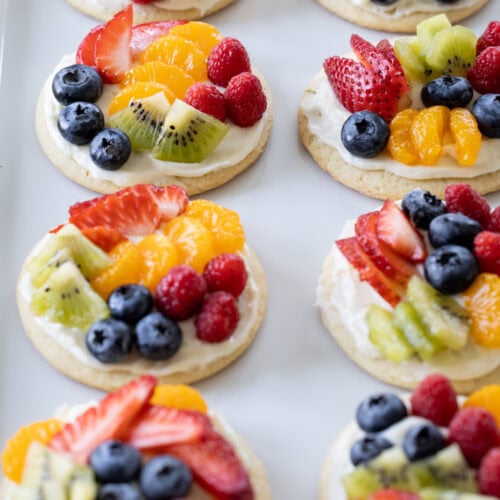 white platter plate filled with mini fruit pizzas.