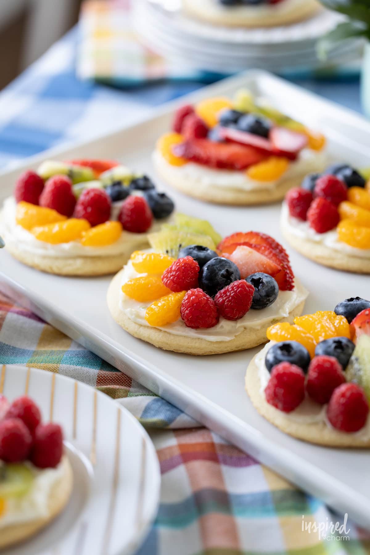 mini fruit pizzas on a white platter.
