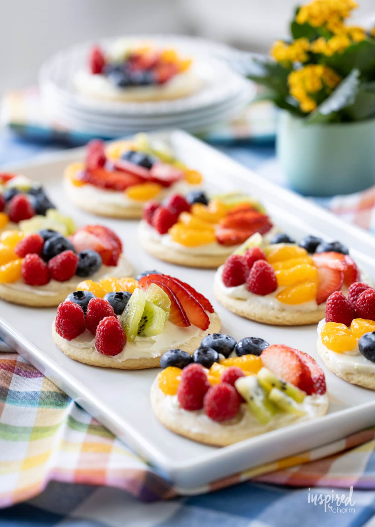 table set with a plate of mini fruit pizzas. 