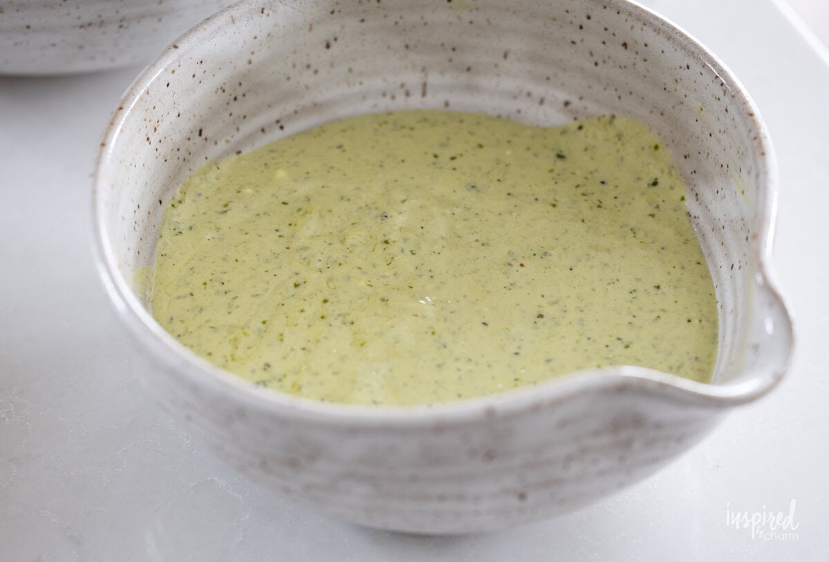 bowl filled with dressing for Pesto Chicken Potato Salad.