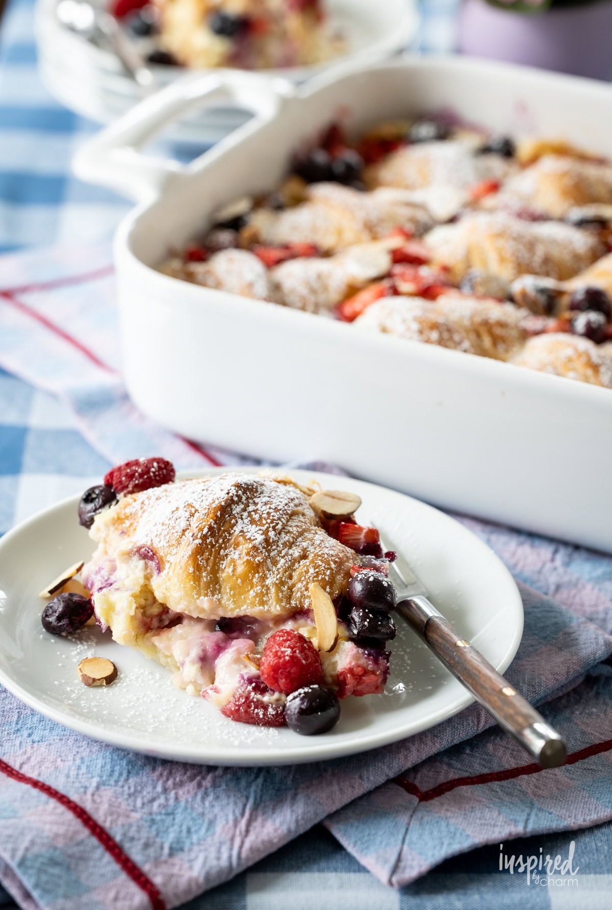 Mixed Berry Croissant Breakfast Casserole in a dish and served on a plate.