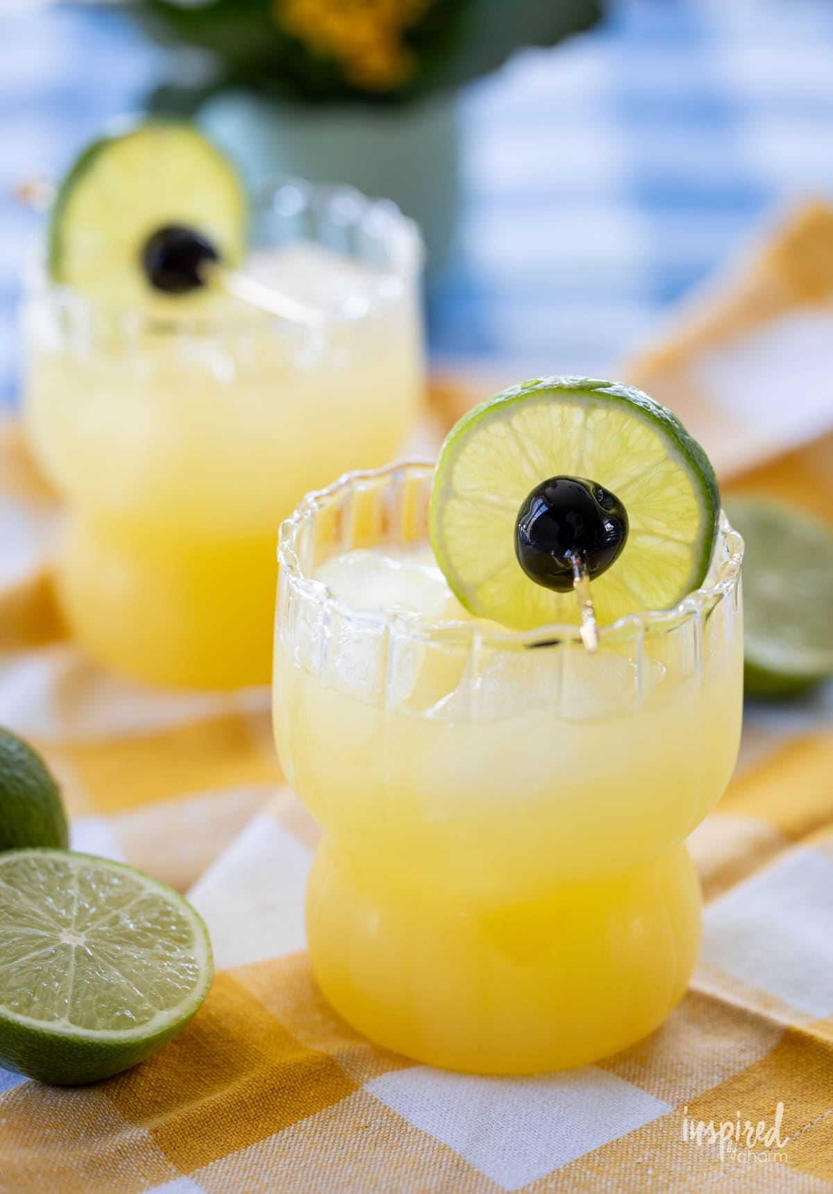 two Black Eyed Susan Cocktails in glasses on a table.