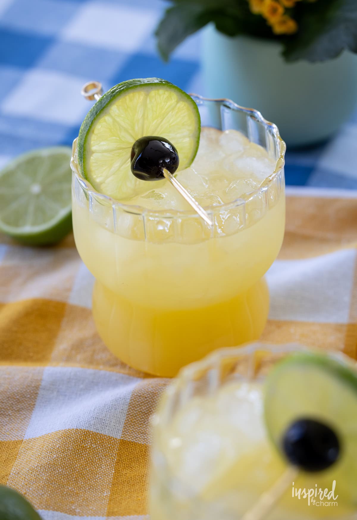Black Eyed Susan Cocktail in a glass with cherry and lime. 