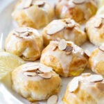 nine Lemon Almond Cream Cheese Puff Pastries on a white plate.
