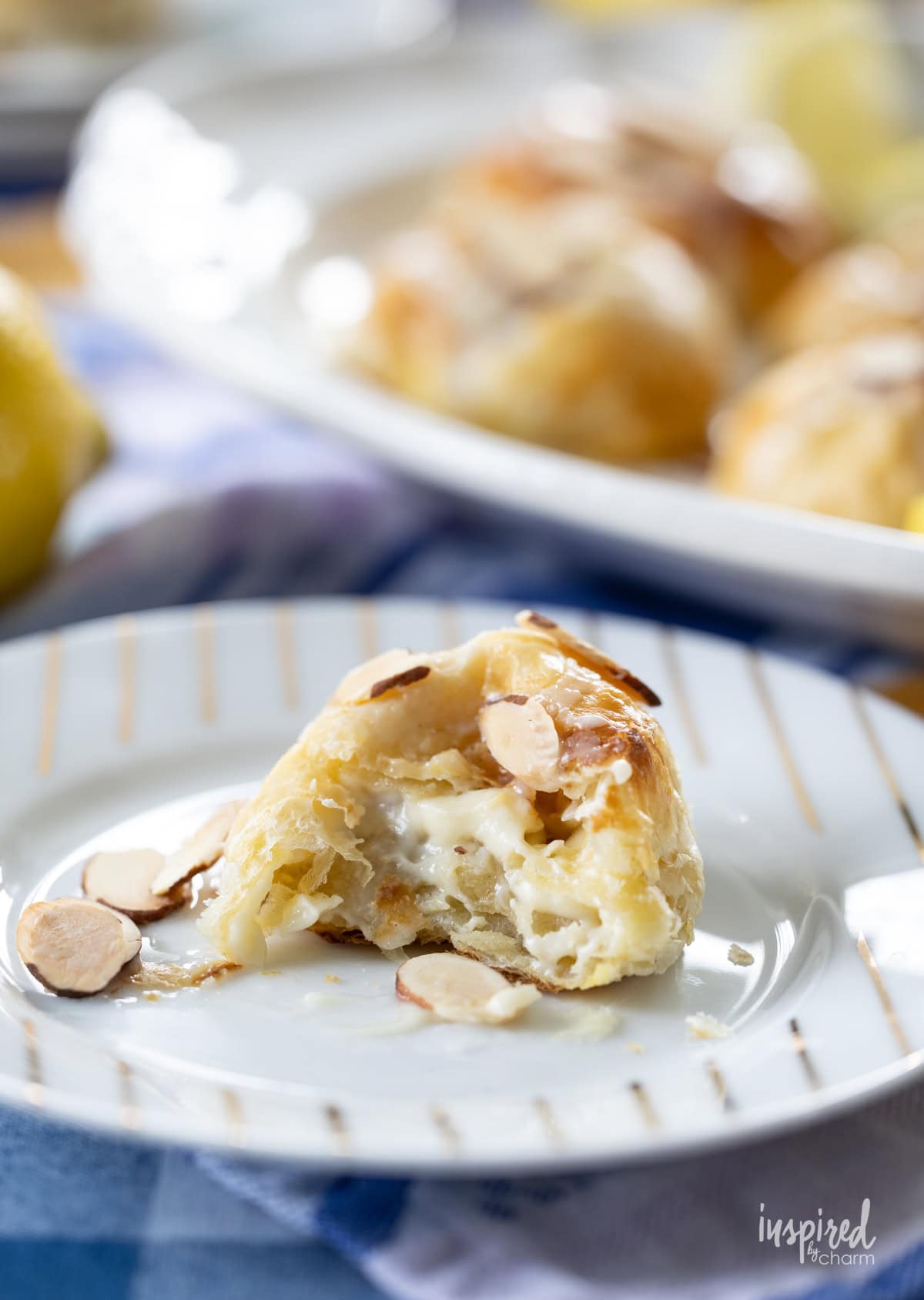 Lemon Almond Cream Cheese Puff Pastry on a plate with a bite taken out.