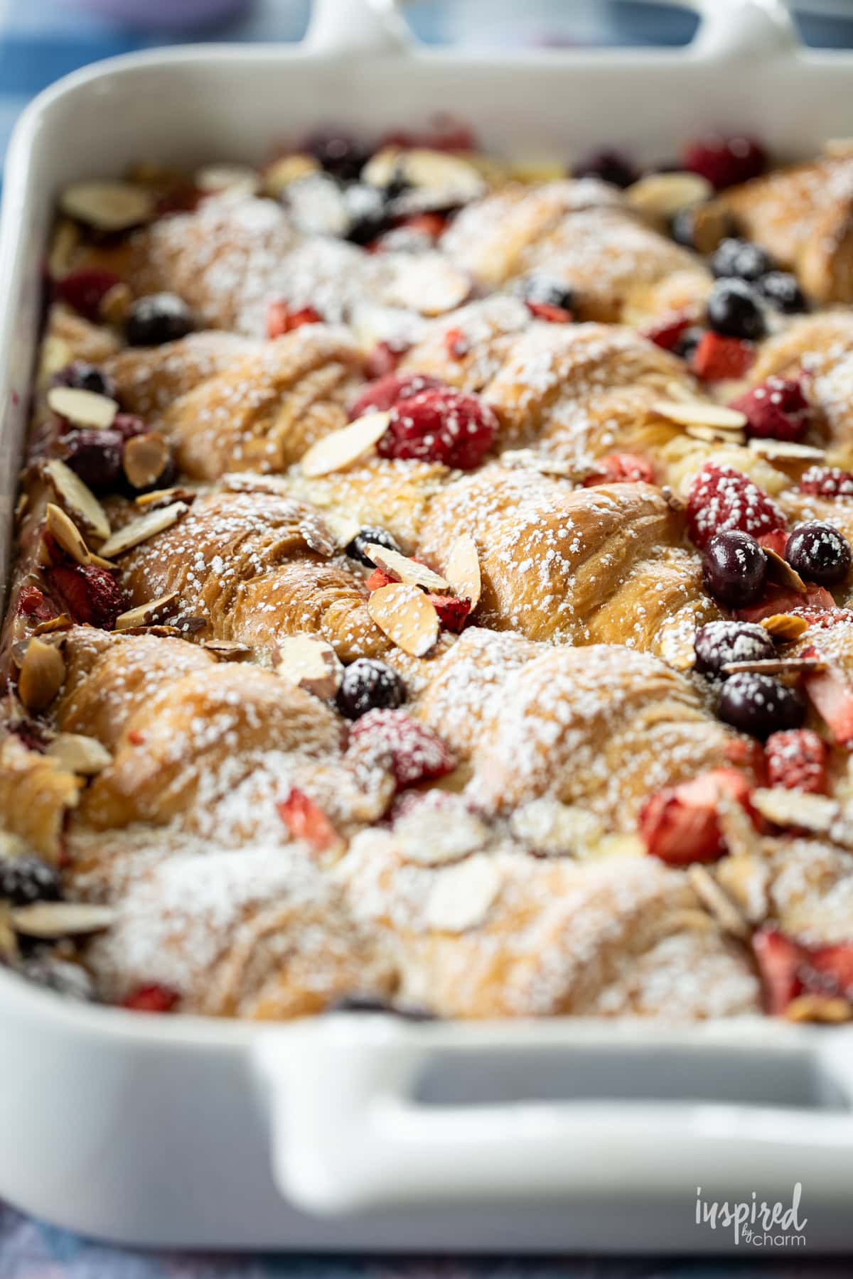 Mixed Berry Croissant Breakfast Casserole in a casserole dish with berries.