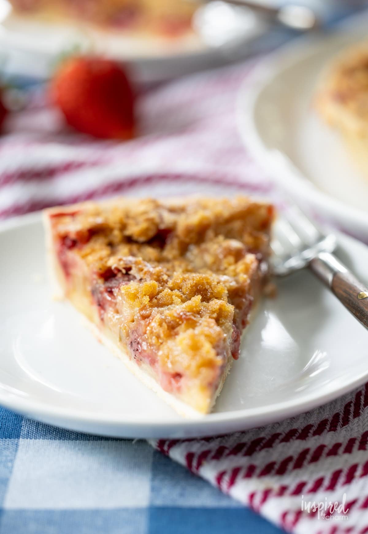 Strawberry Rhubarb Tart slice on a plate with a fork.
