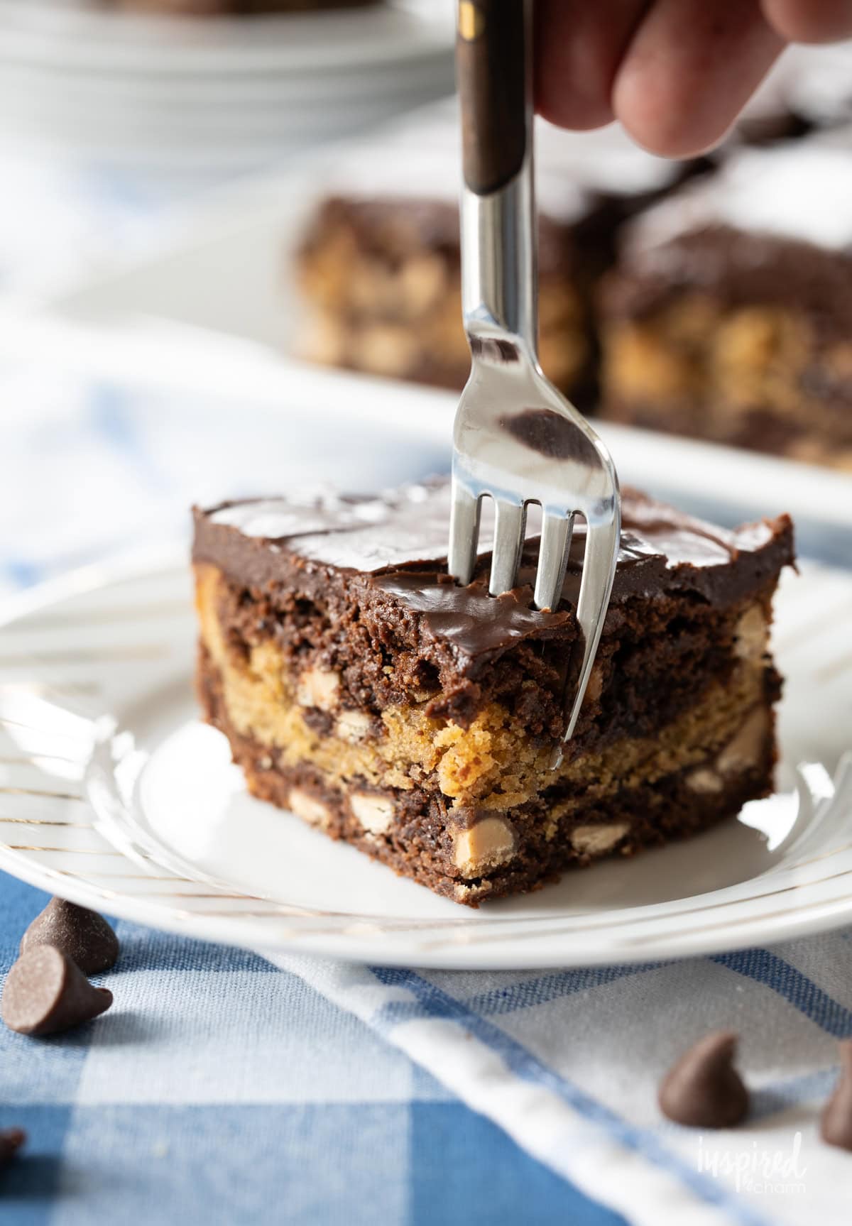 hand with a fork taking a bite of peanut butter and fudge brownies.