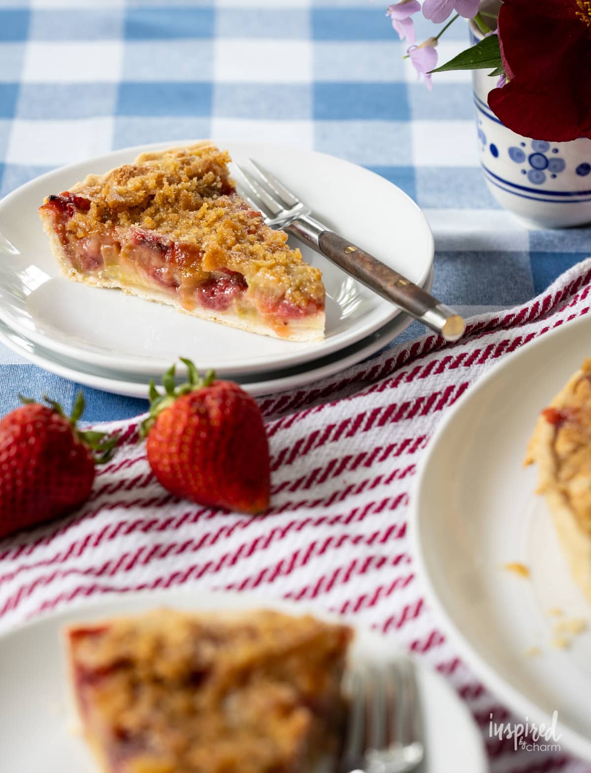 slice of Strawberry Rhubarb Tart on a small plate on table.