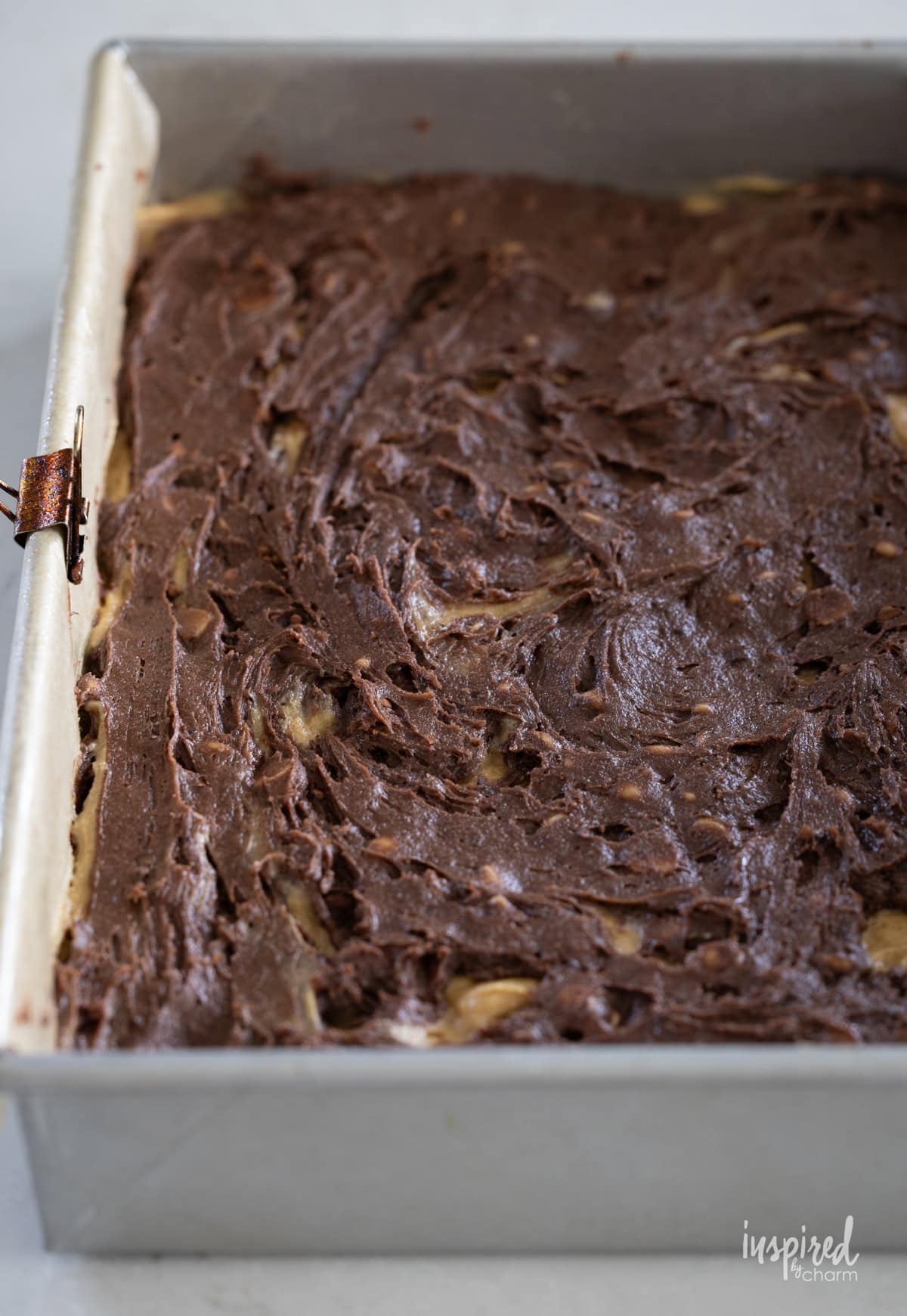 peanut butter and chocolate layered brownies in a pan. 