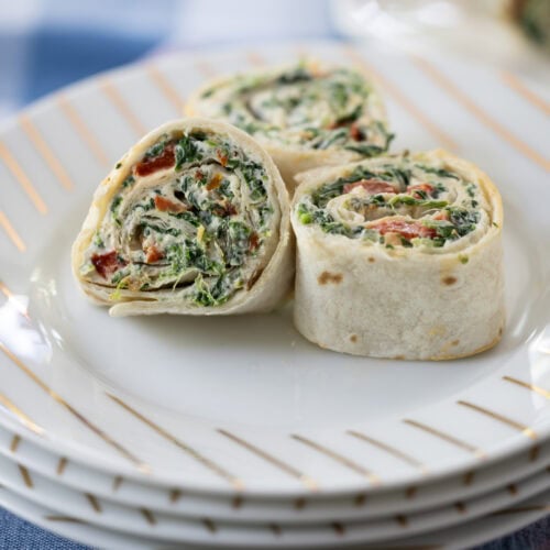three Spinach Dip Roll-Ups on a plate.