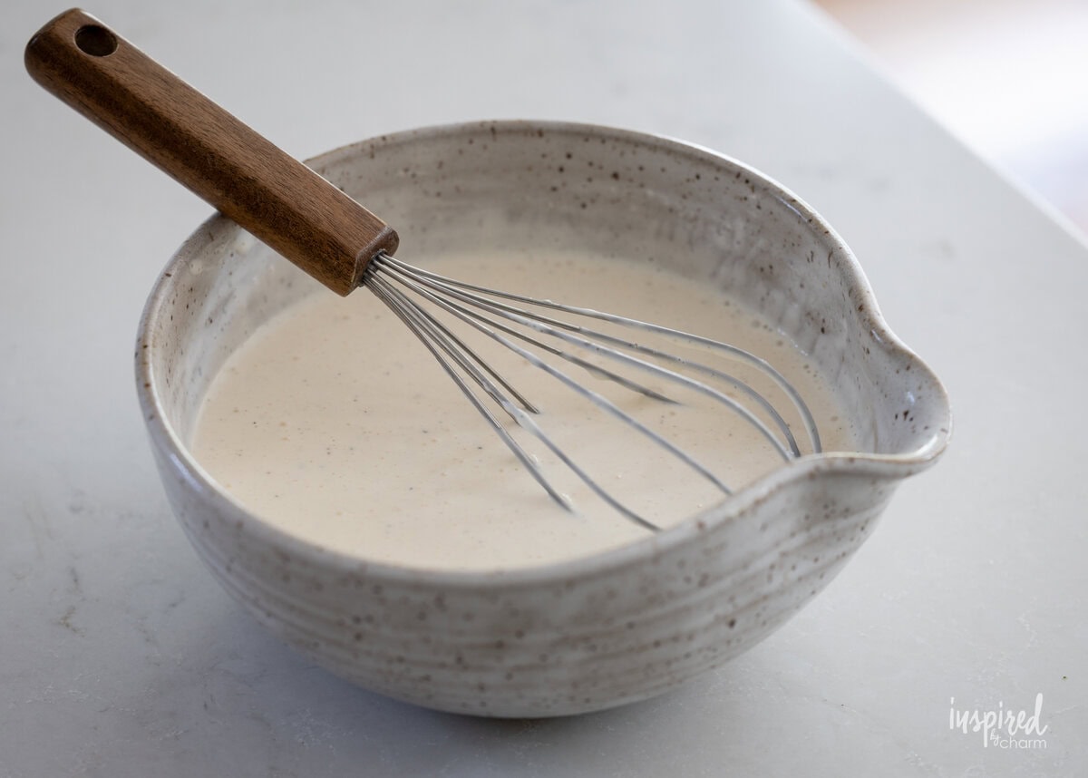 Broccoli Pasta Salad dressing in a bowl with a whisk.