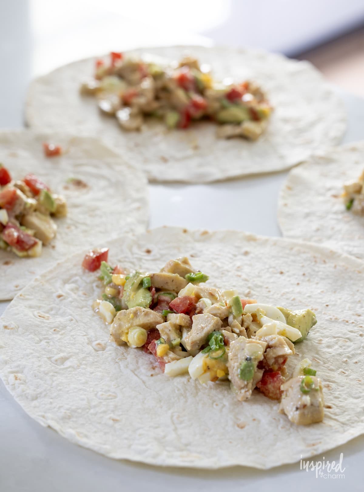 tortilla wraps with Cobb salad ingredients spread on them. 