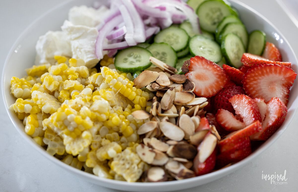ingredients in a bowl for Crispy Chicken Strawberry Corn Salad.