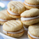 stack of Brown Sugar Cream Sandwich Cookies on a cake stand.