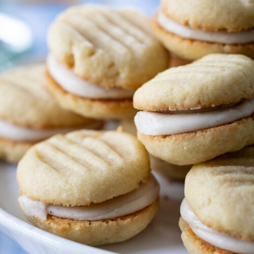 stack of Brown Sugar Cream Sandwich Cookies on a cake stand.