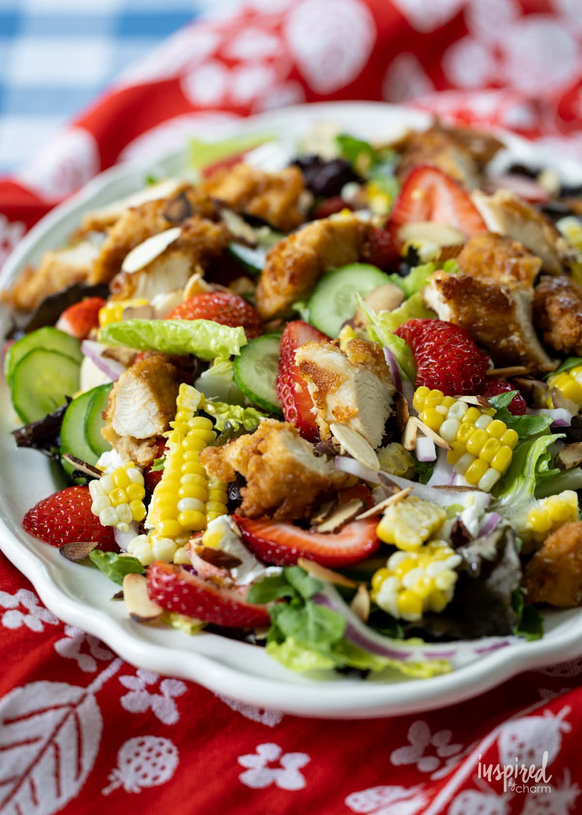table with plate filled with Crispy Chicken Strawberry Corn Salad.