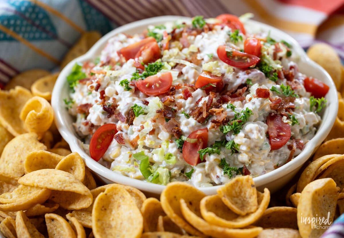 bowl of BLT Corn Dip served with Fritos scoops.