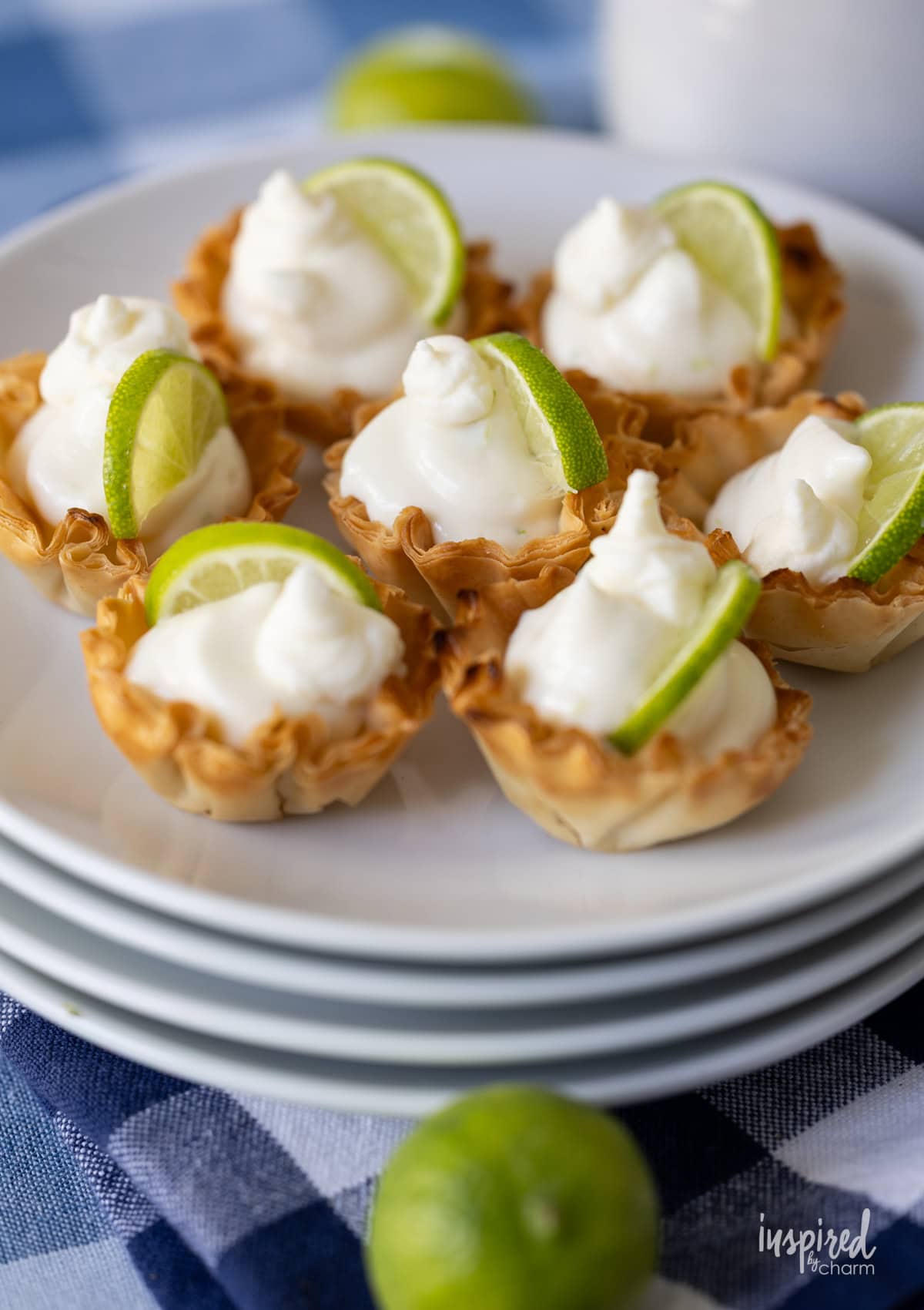 array of Key Lime Pie Tartlets on a stack of plates.