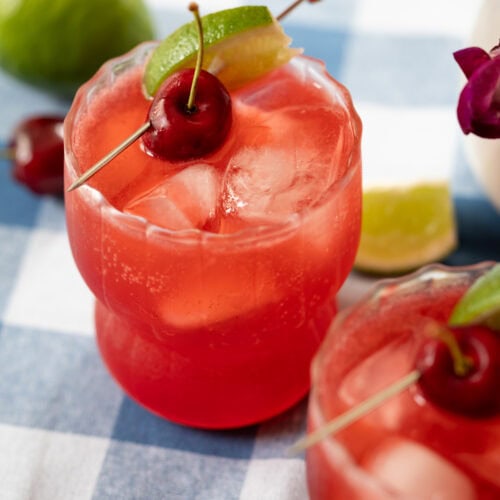 glass of cherry lime splash drink on a table.