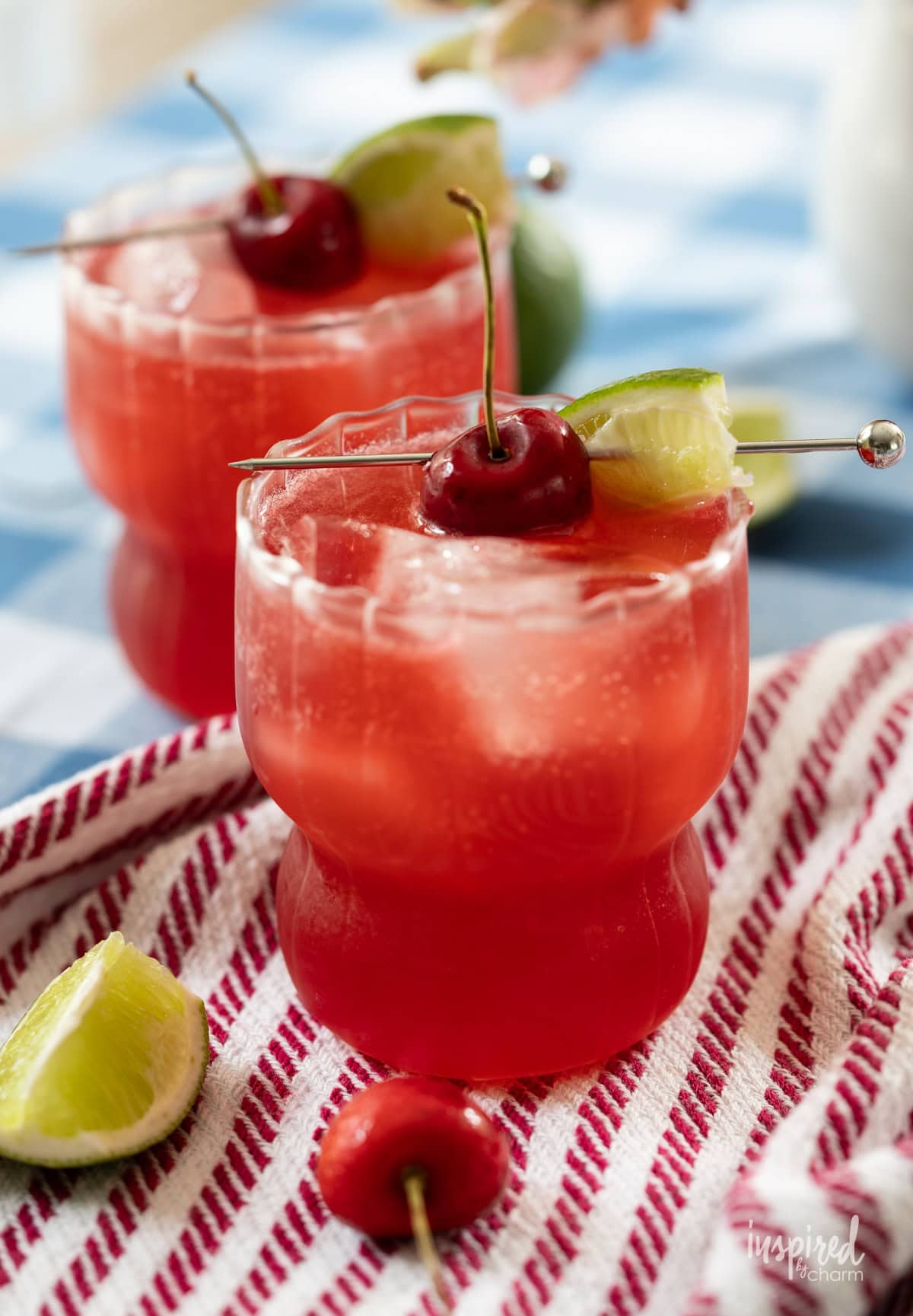 Cherry Lime Splash cocktail served in two glass with cherry and lime garnish. 