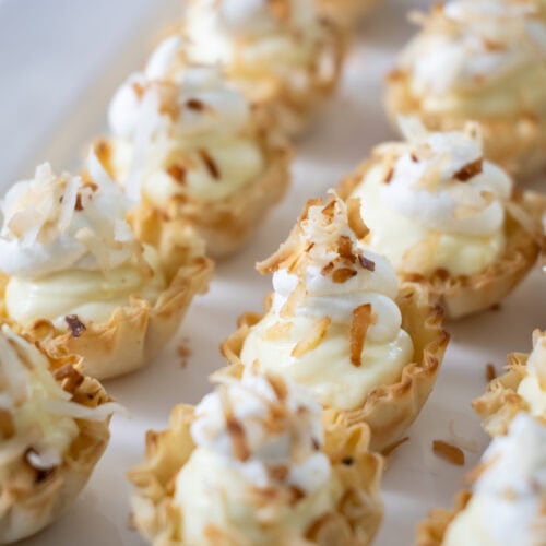 rows of Mini Coconut Cream Pie Tartlets on a platter.