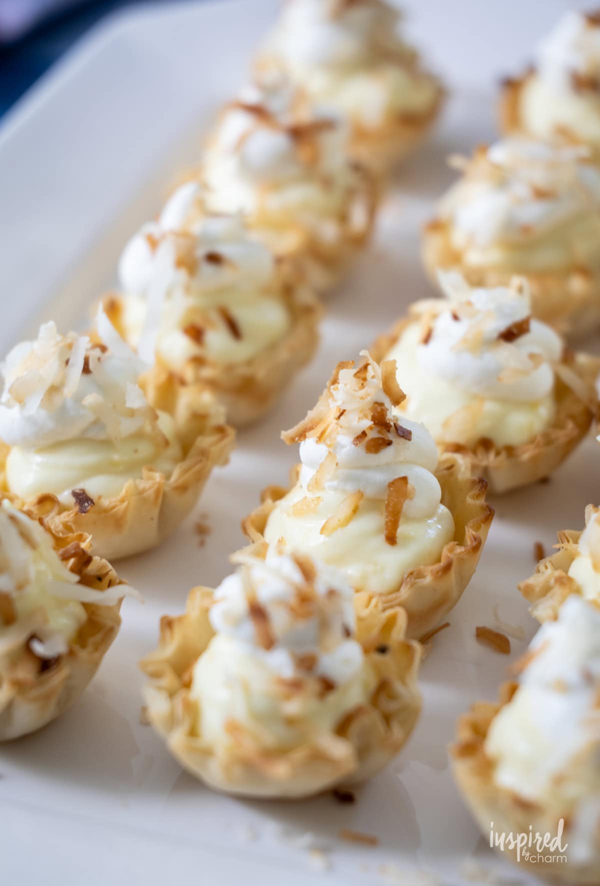 rows of Mini Coconut Cream Pie Tartlets on a platter.
