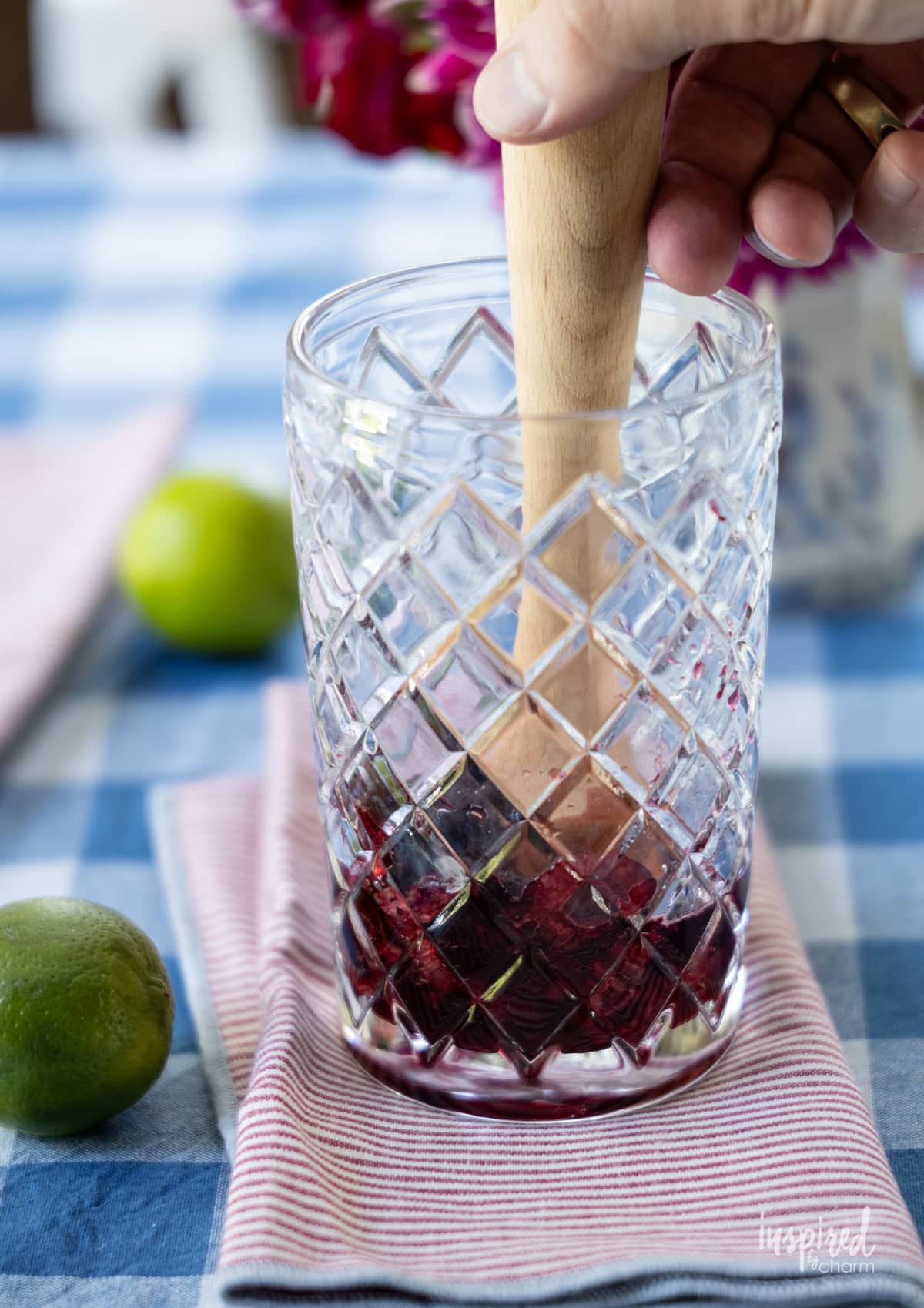 muddling cherries in a glass.