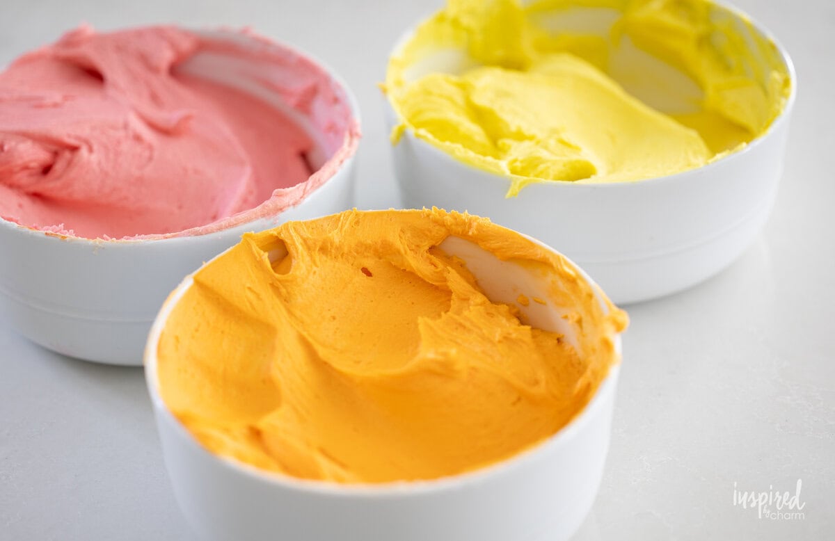 three bowls of colored frosting. 