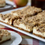 Apple Butter Cheesecake Bars on a table decorated for fall.