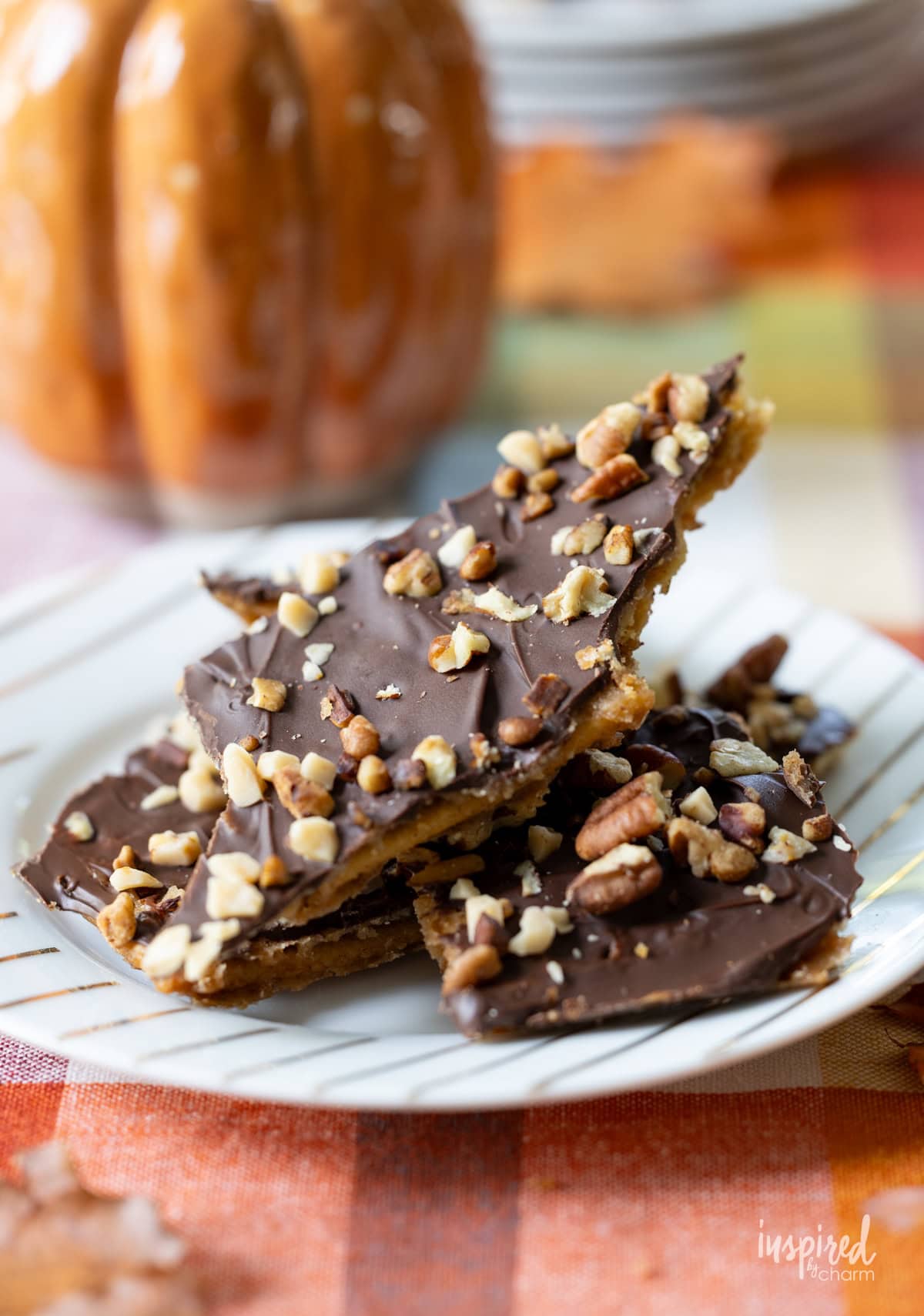 a few pieces of Pumpkin Spice Cracker Toffee on a plate.