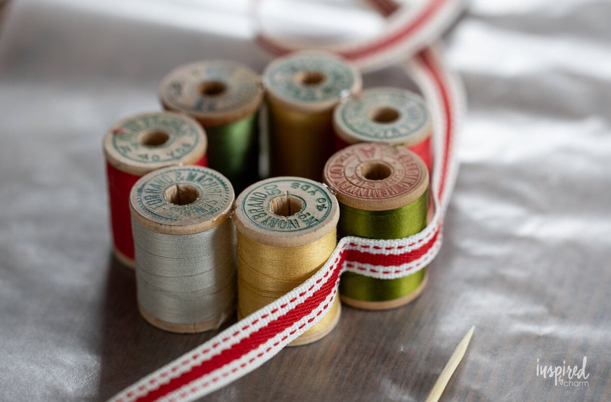 adding ribbon to vintage spool wreath.