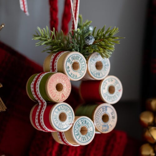 Vintage Thread Spool Mini Wreath hung on a peg.