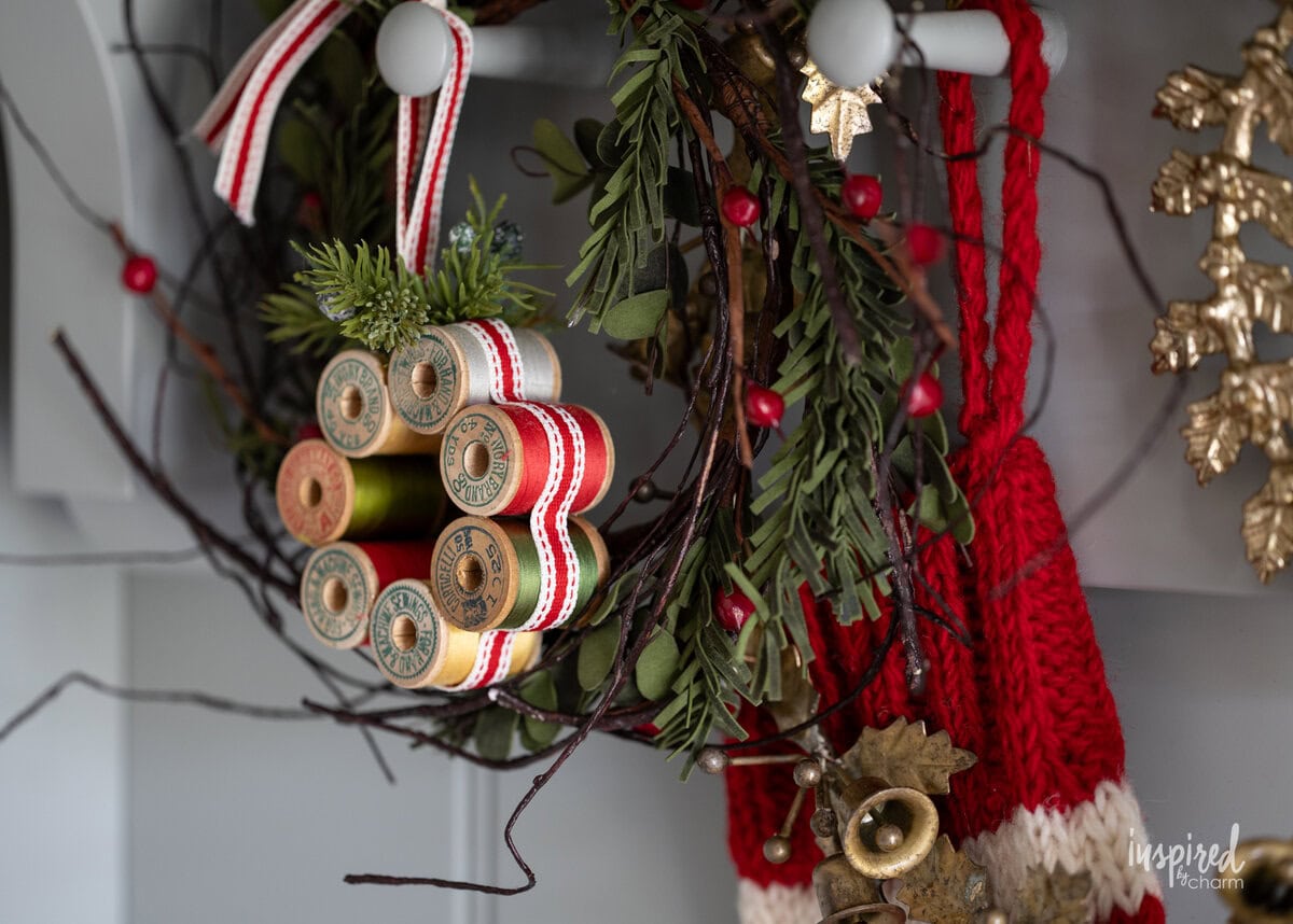Vintage Thread Spool Mini Wreath hung on a peg.